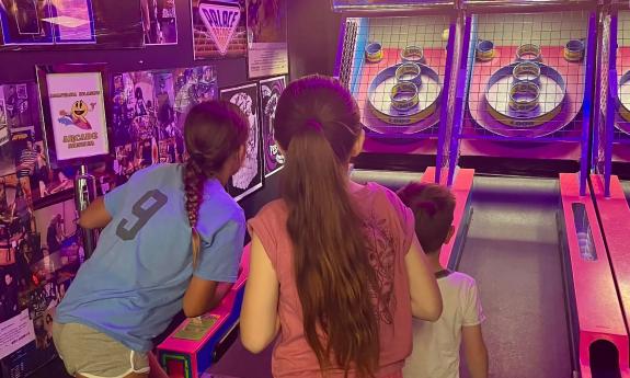 Three younsters playing an arcade game