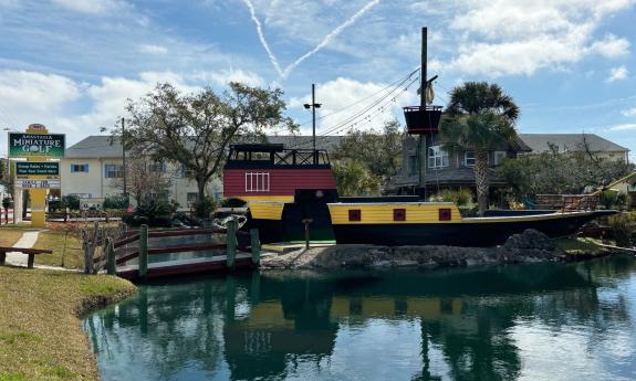 The pirate ship at a miniature golf attraction sits on an inland sea