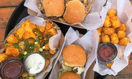 Various sliders and tater tots with side sauces