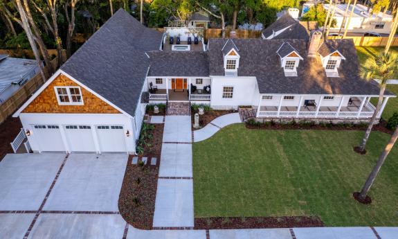 Seen from above, this expanded old home now has a large driveway, ramp, garage, and porches