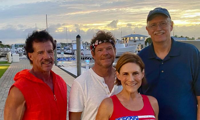 The foursome dance band Glory standing togehter at a marina