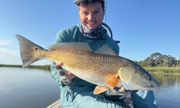 Jack, with a large fish, caught while fishing from a SUP