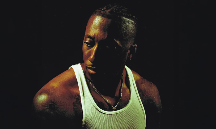 Lecrae poses in front of a black backdrop.